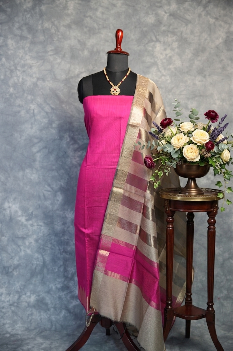 Mannequin wearing a pink saree with a floral arrangement on a gray background