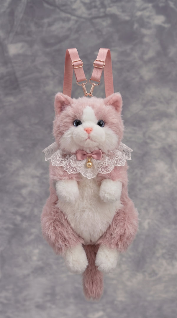 A pink and white plush cat backpack with a lace collar, bow, and gold bell, featuring pink shoulder straps and a gold chain connector, set against a textured gray background.